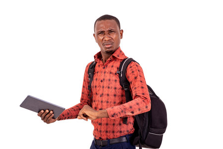 young disgruntled student man with backpack holding digital tablet