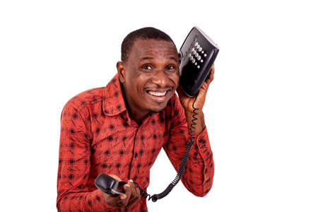 a handsome businessman in checkered shirt standing over white background holding phone, laughing.の写真素材