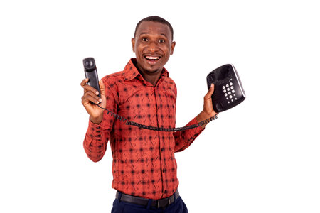 a handsome businessman in checkered shirt standing over white background holding phone and looking...