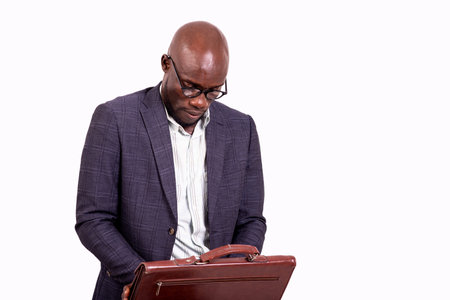 portrait of a serious businessman wearing glasses, looking inside his briefcase.