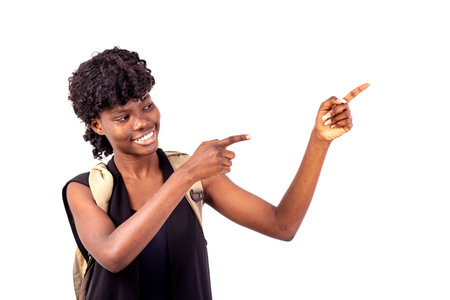 young student girl wearing a backpack pointing fingers to the side smiling.