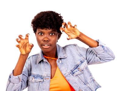 young female student in jacket standing on white background making scary faces widening her eyes.の写真素材
