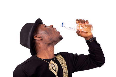 portrait of a well-dressed young man drinking mineral water from a plastic bottle.の写真素材