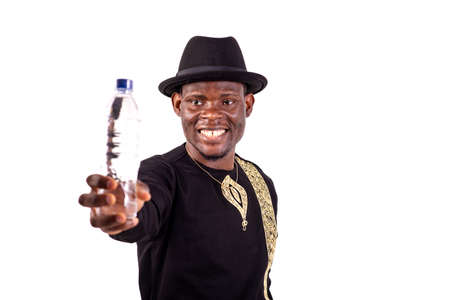 a handsome businessman in embroidered shirt standing over white background presenting a bottle of water, smilingの写真素材