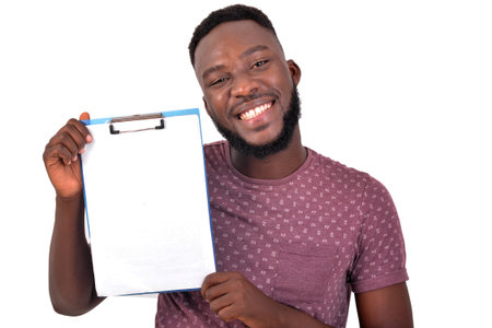 portrait of a young man holding clipboard while smiling at the camera.