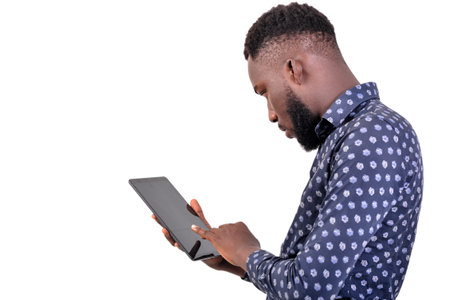 a young bearded man standing over white background doing research with tablet
