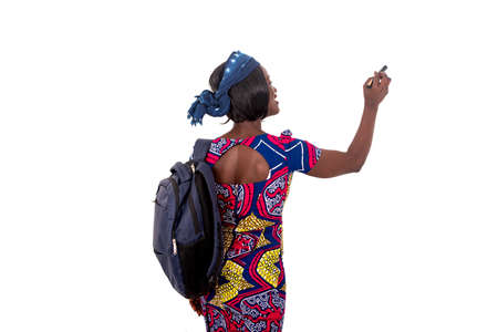 portrait of a beautiful young student girl carrying a backpack and writing on a whiteboard with a marker.の写真素材