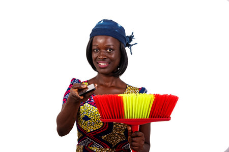portrait of a young housewife holding a broom and giving a mobile phone while smiling.