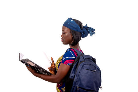 portrait of a beautiful young student girl carrying a backpack and checking the notes in the notebook.の写真素材