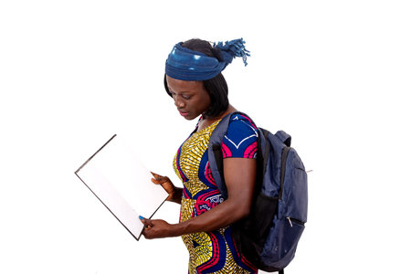 portrait of a beautiful young student girl carrying a backpack and checking the notes in the...