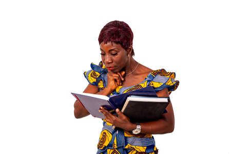 Mature business woman in traditional attire standing on white background reading documents with hand under chin.の写真素材