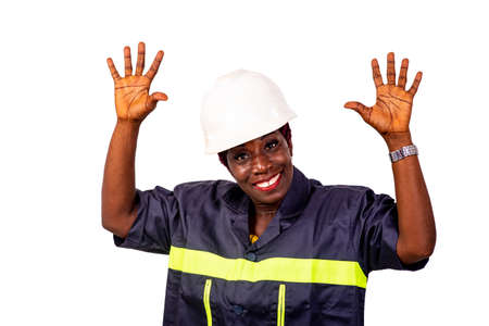 portrait of a beautiful female engineer or worker wearing white helmet and work uniform raising hands up while smiling.の写真素材