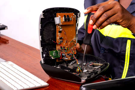 hands of a technician repairing a mobile phone with screwdriver.の写真素材