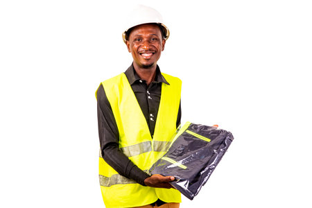young happy engineer man wearing green vest and white safety helmet while holding working uniform.