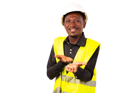Young man engineer wearing a green vest and a white safety helmet while showing his empty palms...