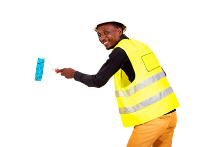 young painter man wearing green vest and safety helmet paints the wall with a brush roller while...