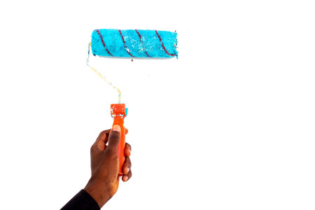 hand of a painter person holding a brush roll on the white wall.の写真素材