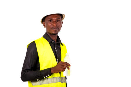young man technician wearing green vest and safety helmet holding plastic mineral water bottle.の写真素材