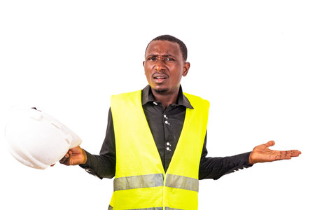 young confused engineer man wearing green vest and safety helmet with arms and hands raised.