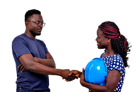 young man shaking hands with young female construction engineer while smiling.の写真素材