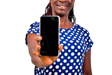 a beautiful woman standing on white background presenting mobile phone, smilingの写真素材