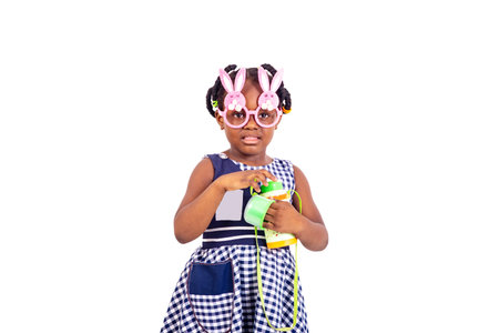 cute little girl dressed in school clothes wearing toy glasses and opening a gourd.