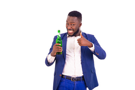 portrait of a handsome young businessman holding a bottle of beer and showing his thumb while...