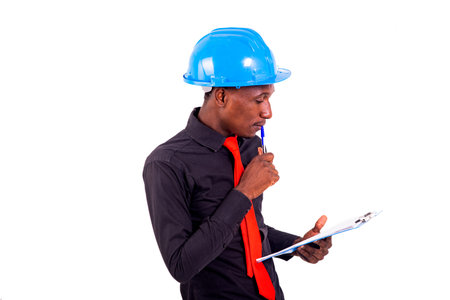 young man engineer wearing blue safety helmet and reading document note on clipboard.