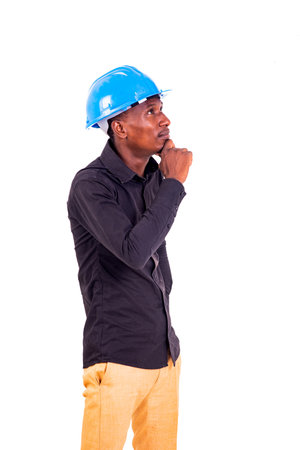 portrait of a young male construction engineer holding hand under chin and thinking about something while looking aside.の写真素材