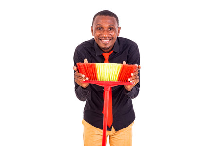 portrait of a young businessman holding a broom while smiling.の写真素材