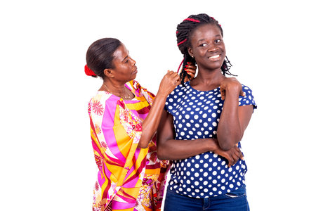 woman looking and touching her friend's braided hair.の写真素材