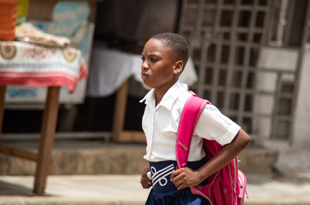 Abidjan, ivory coast 16, 2022 : portrait of young girl in blue and white with a backpack going to school in the afternoon.のeditorial素材