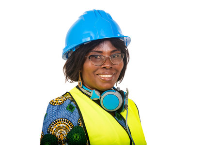 beautiful female engineer in protective helmet standing over white background looking at camera smiling.の写真素材