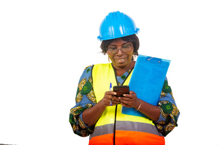 a beautiful female engineer in protective helmet standing over white background with spirited clipboard manipulating while laughing.の写真素材