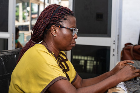 a beautiful young businesswoman in glasses sitting at the office working with computer.の写真素材