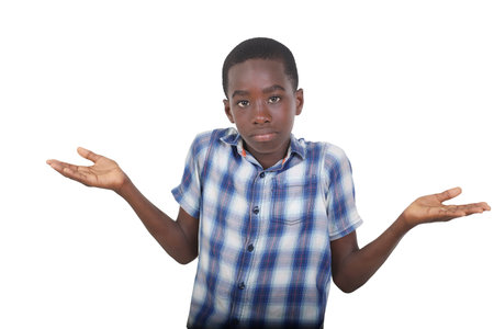 handsome young boy in shirt standing over white background shrugging shoulders while showing palms.の写真素材