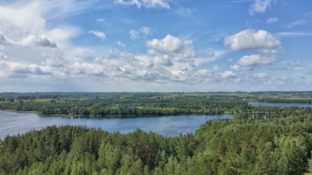 Picturesque view on the lake and forest at evening time just before the sunset. Sky and clouds reflected in water surface.Beautiful natural landscape. Panoramic view. The land of lakes. Europe.の写真素材