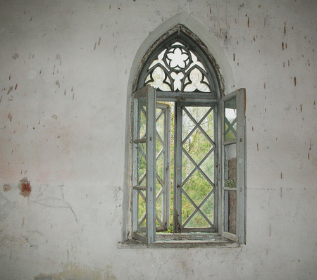 Old window on the old wall with cracked plaster.の写真素材
