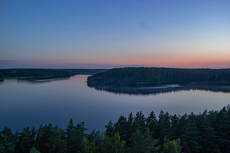 Peaceful night scene with the starry sky at a lake in Lithuania. Reflection of stars on the still...