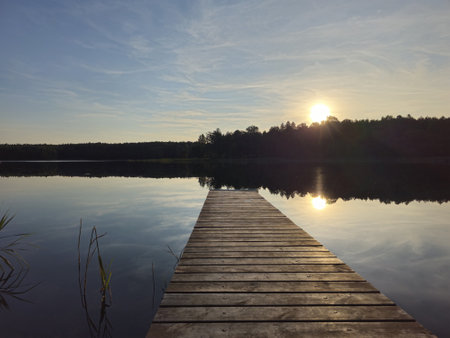 A fishing rod on a wooden bridge by the lake. Lithuaniaの写真素材
