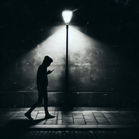 Silhouette of a young man walking in the street at nightの素材