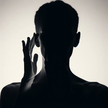 Silhouette of a young man with hands on his face.の素材