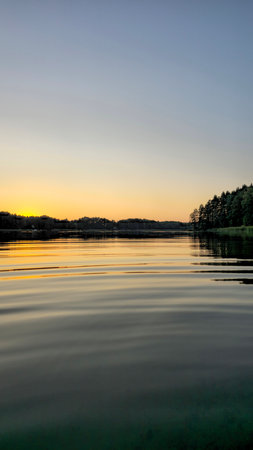 Tranquil Sunset Over a Calm Forested Lake. Nord Europeの写真素材