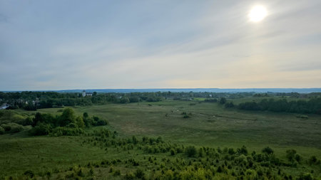 Expansive view of farmland and natural landscape in late afternoon light over rural countryside....