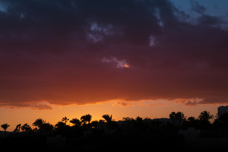 beautiful three-color sunset over african townの写真素材