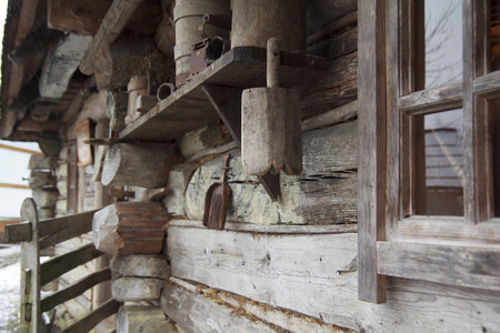 Ancient authentic ukrainian wooden hut, wall with window and other retro self-made householdの写真素材
