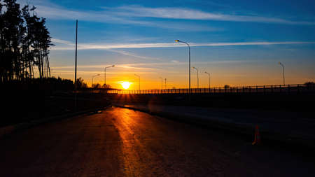 Sunset on the highway.Autumn sky at sunset Sunset is the edge of the forest. Evening sunset.stripes from planes.Blue skyの写真素材