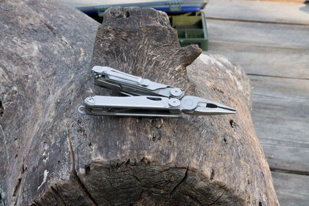 Multifunctional tool for fishing. Plier on wood. Plier for fishing.