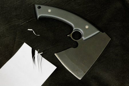 Ax on black background with paper. Outdoor.