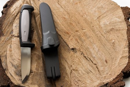 Knife on a wooden background with a plastic cover.の写真素材